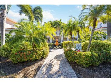 Beautiful condo building entrance with lush tropical landscaping and charming walkway at 4264 Central Sarasota Pkwy # 125, Sarasota, FL 34238