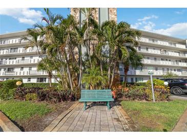 Beautiful condo building featuring a welcoming bench, lush landscaping, and secure parking at 4440 Ironwood Cir # 508D, Bradenton, FL 34209