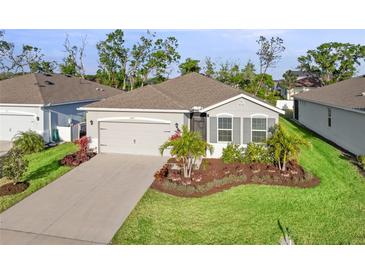Lovely single-story home boasts a lush green lawn and a convenient two-car garage at 5727 Oak Bridge Ct, Bradenton, FL 34211