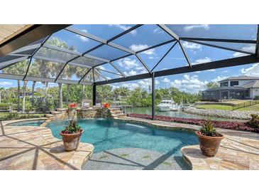 The screened pool area includes a spa and picturesque waterfront views with lush tropical landscaping at 452 Picasso Dr, Nokomis, FL 34275