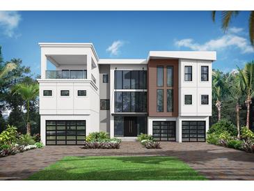 Modern three-story home featuring a clean white facade, a balcony, and two-car garage at 5210 Inspiration Ter, Bradenton, FL 34210