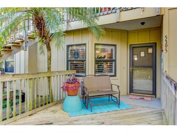 Inviting front porch with seating area, a palm tree and a welcoming entrance to the home at 5395 Lake Arrowhead Trl # 24, Sarasota, FL 34231