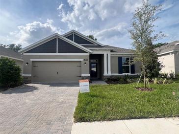 Beautiful single-story home with a brick paver driveway and manicured lawn at 19575 Fort King Run, Brooksville, FL 34601
