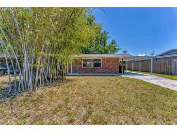 Charming brick home with carport and mature bamboo landscaping in the front yard at 3545 Lalani Blvd, Sarasota, FL 34232