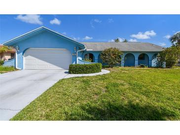 Charming blue single-story home featuring a well-manicured lawn and an attached two-car garage at 6004 10Th Ave W, Bradenton, FL 34209