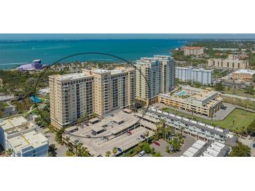 Stunning aerial view of high-rise condos with waterfront views, parking, and meticulous landscaping at 750 N Tamiami Trl # 304, Sarasota, FL 34236
