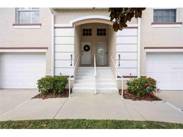 Inviting townhome entrance featuring a well-maintained walkway, landscaping, and unit numbers above each front door at 6314 Bay Cedar Ln # 201, Bradenton, FL 34203