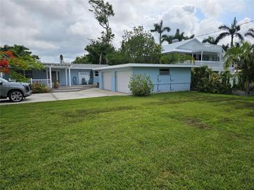 Charming blue home with a well-manicured lawn and attached two-car garage at 1654 Blakemore Ln, Sarasota, FL 34231