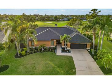 Beautiful single-story home featuring lush landscaping, a well-manicured lawn, and a dark roof, complemented by swaying palm trees at 3941 Spyglass Hill Rd, Sarasota, FL 34238