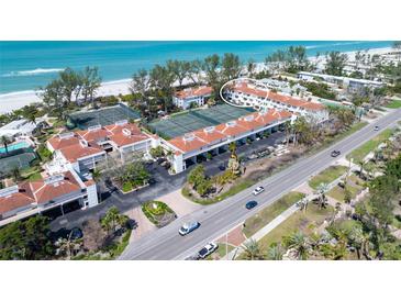 Stunning aerial view of beachfront condos with tennis courts, lush landscaping, and ocean views at 5055 Gulf Of Mexico Dr # 435, Longboat Key, FL 34228