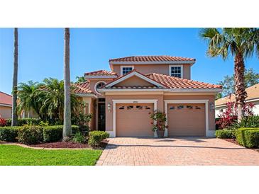 Charming home features a red tile roof, brick driveway, manicured landscaping and a 2 car garage at 6442 Tailfeather Way, Bradenton, FL 34203