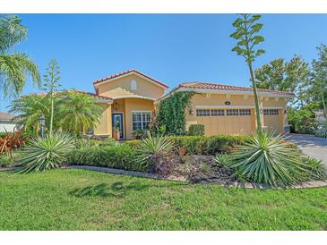 Charming home featuring a terra cotta roof, lush landscaping, and verdant lawn at 6600 Horned Owl Pl, Sarasota, FL 34241
