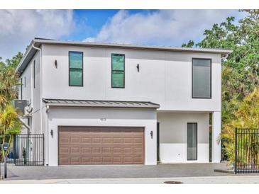 Modern two-story home with a white facade, brown garage door, and well-manicured landscaping at 4112 Swift Rd, Sarasota, FL 34231