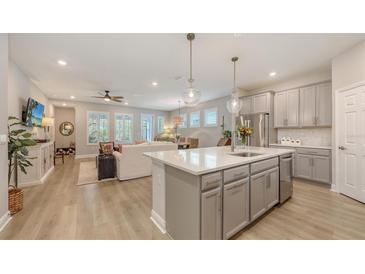 Open kitchen boasts an island with white countertops, stainless steel appliances and pendant lighting at 8110 Trimbelle Ter, Parrish, FL 34219
