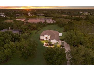 Wide aerial shot showcases the home's private lake view and manicured lawn at 8223 Snowy Egret Pl, Bradenton, FL 34202