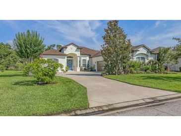 Stunning home features lush landscaping, a blue front door, and a winding driveway, adding to its curb appeal at 13130 50Th E Ct, Parrish, FL 34219