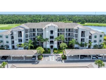 Spacious condo building with covered parking, balconies, and lush landscaping at 17704 Gawthrop Dr # 102, Bradenton, FL 34211