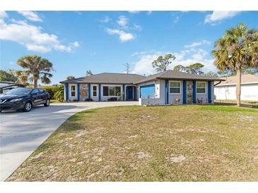 Charming single-story home with a well-maintained lawn and mature palm trees at 18033 Edgewater Dr, Port Charlotte, FL 33948