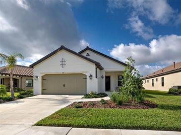 Charming single-story home featuring a two-car garage, neutral paint, dark accents, and manicured landscaping at 208 Potenza Loop, Nokomis, FL 34275