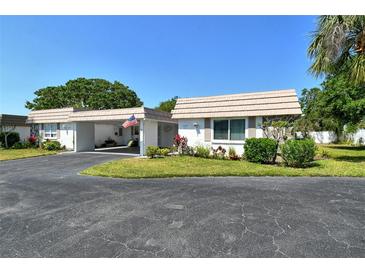 Charming single-story home featuring a stone accent wall, well-kept lawn, and a welcoming carport at 2417 Riverbluff Pkwy # 235, Sarasota, FL 34231