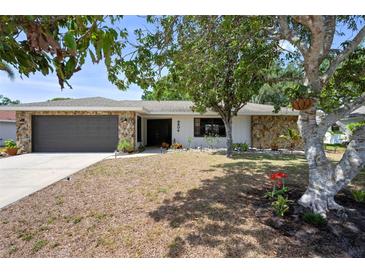 Beautiful single-story home with stone facade, mature trees, and a well-maintained lawn at 6604 23Rd W Ave, Bradenton, FL 34209