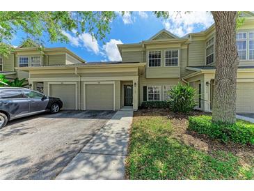 Inviting townhome featuring a two-car garage, neutral exterior, and well-maintained landscaping at 7576 Plantation Cir, Bradenton, FL 34201