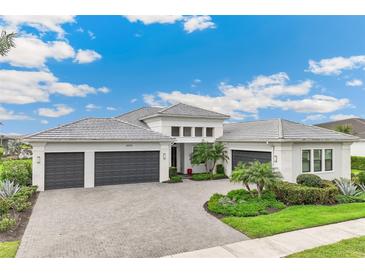 Beautiful single-Gathering home with a three-car garage and a well-manicured front yard at 8936 Artisan Way, Sarasota, FL 34240