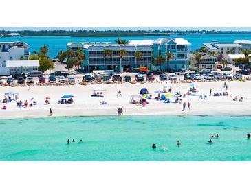A gorgeous beach view near the property featuring white sand, clear turquoise water, and relaxing beachgoers at 901 Gulf S Dr # 14, Bradenton Beach, FL 34217