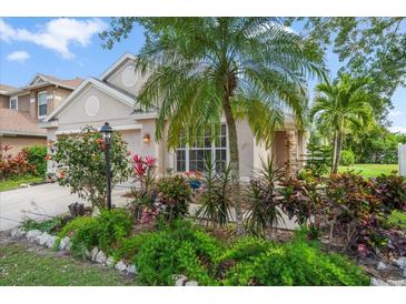 Charming home with lush landscaping, tropical plants, and a well-manicured lawn at 15032 Skip Jack Loop, Lakewood Ranch, FL 34202