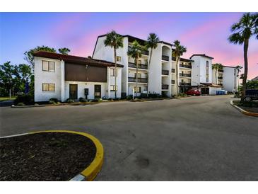 Charming condo building with Spanish-style architecture and mature palm trees at 1624 Stickney Point Rd # 24-206, Sarasota, FL 34231
