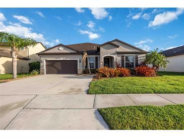 Charming one-story home featuring a well-manicured lawn and colorful landscaping at 11092 58Th Street Cir E, Parrish, FL 34219