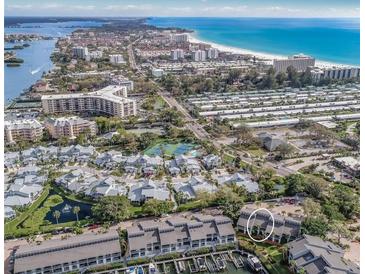 Stunning aerial view of waterfront community with beaches, docks and residences on a clear, sunny day at 1235 Dockside Place # 108, Sarasota, FL 34242