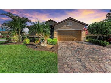 Charming single-Gathering home featuring a brick-paved driveway, lush landscaping, and an attached two-car garage at 135 Sweet Tree St, Bradenton, FL 34212
