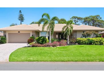 Inviting single-story home featuring mature landscaping, a well manicured lawn, and a neutral color palette at 142 Dory Ln, Osprey, FL 34229