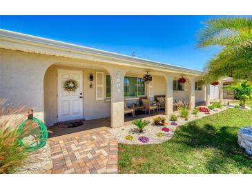 Charming front porch with seating area, decorative flowers, and lush landscaping enhancing curb appeal at 2605 Sunnybrook Dr, Sarasota, FL 34239