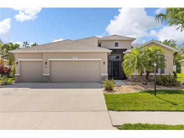 Charming home featuring a well-manicured lawn, a three-car garage, and stone accents at 2819 130Th E Ave, Parrish, FL 34219
