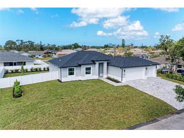 Well-manicured lawn complements this newly built home featuring a spacious three-car garage and paver driveway at 5322 Syracuse Rd, Venice, FL 34293