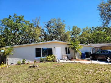 Charming single-story home featuring a well-maintained front yard and mature trees at 2035 Vinson Ave, Sarasota, FL 34232