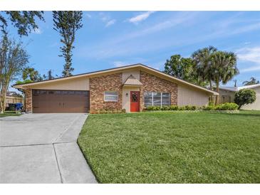 Charming single-story home features a brick facade, well-manicured lawn, and inviting red front door at 2551 Waneta Dr, Sarasota, FL 34231