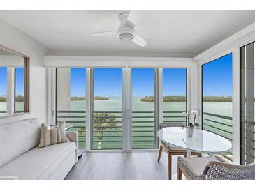 Bright living space with water views, light wood floors, and a ceiling fan for a cozy ambiance at 4310 Falmouth Dr # 305, Longboat Key, FL 34228