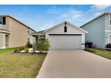Charming single-Gathering home featuring a well-manicured lawn and a two-car garage at 5547 Logan Cave Ave, Wimauma, FL 33598