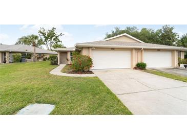 Charming home featuring an attached garage and a well-manicured lawn at 5689 Evergreen Dr # 18, Sarasota, FL 34233