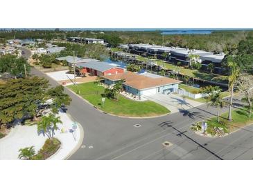 Aerial view of single-story home, showcasing lush landscaping and neighborhood canal access at 10304 Sandpiper W Rd, Bradenton, FL 34209