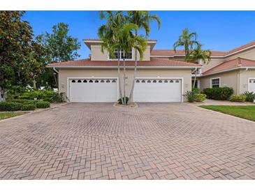 Spacious red brick driveway leading to a home with a two-car garage and lush landscaping at 197 Tropicana Dr # 1511, Punta Gorda, FL 33950