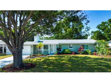 Charming single-story home featuring a well-maintained lawn, mature trees, and colorful landscaping at 2238 Rose St, Sarasota, FL 34239