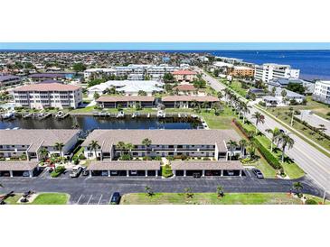 An aerial view of waterfront condominiums with boat docks and a canal leading to the water at 245 Coldeway Dr # B10, Punta Gorda, FL 33950
