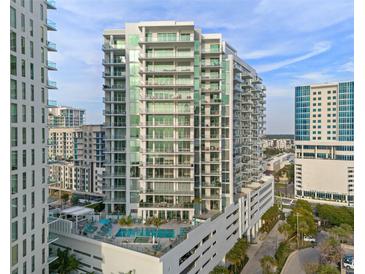 Modern high-rise condo exterior showcasing a pool, balconies, and stylish architectural design at 301 Quay Commons # 1204, Sarasota, FL 34236
