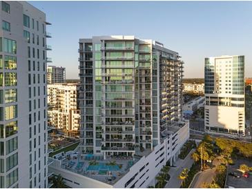 Modern condo building featuring balconies and a pool, with surrounding city views at 301 Quay Commons # 1610, Sarasota, FL 34236