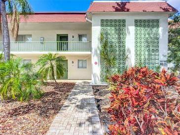 Charming condo exterior featuring a brick walkway, green doors and trim, and colorful landscaping at 3606 Beneva Rd # 506, Sarasota, FL 34232