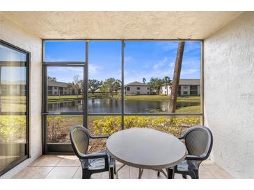Relaxing screened patio with table and chairs overlooking a serene lake view at 4325 46Th W Ave # 104, Bradenton, FL 34210